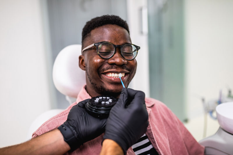 a picture of a dental patient happily getting treated for dental veneers or lumineers by a dental professional at a dental office.